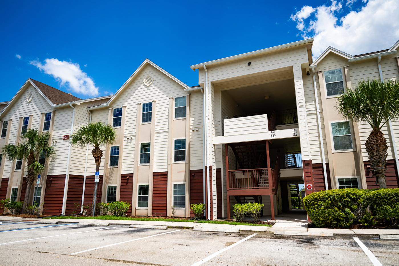 Panther Bay apartment building. A three-story apartment building on a sunny day with palm trees in front.